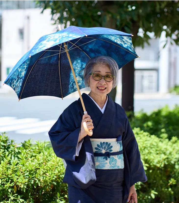 日傘をさして屋外に立つお客様